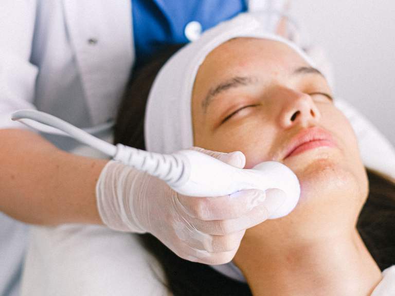 Aplicacao facial com aparelho estetico em ambiente clinico